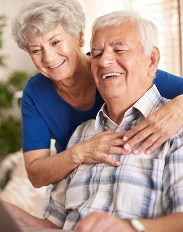 Casal de idosos sorrindo juntos em casa